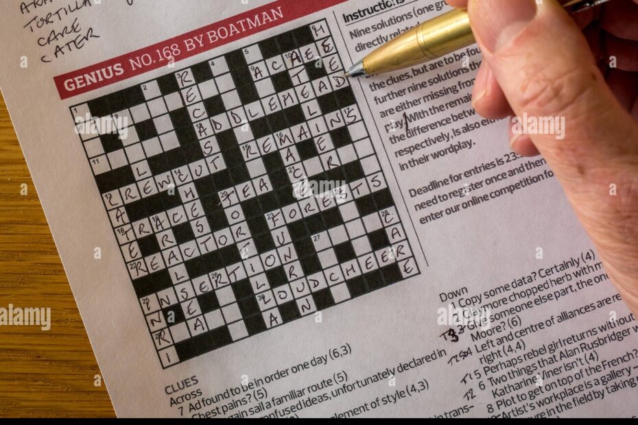 Solving Complicated Crossword Puzzle In The Guardian Newspaper Called Genius By Crossword Setter Nom De Plume Boatman With Man s Hand Holding Pen Stock Photo Alamy
